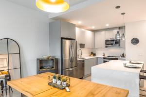 a kitchen with a wooden table and a stainless steel refrigerator at Revelstoke Alpine Retreat - RARE One-Bedroom Condo in Revelstoke +20 photos