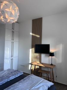 Schlafzimmer mit einem Bett und einem Schreibtisch mit einem TV in der Unterkunft Steinweg 7 Ferienwohnung in Kassel