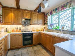 a kitchen with wooden cabinets and a stove top oven at 2 Bed in New Mills 75029 in Mellor