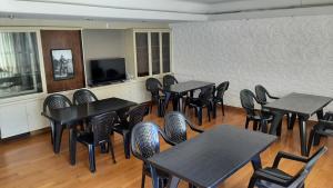 a dining room with tables and chairs and a flat screen tv at 645 Hostel in Mendoza