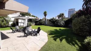 eine Terrasse mit Stühlen und einem Tisch im Hof in der Unterkunft 645 Hostel in Mendoza