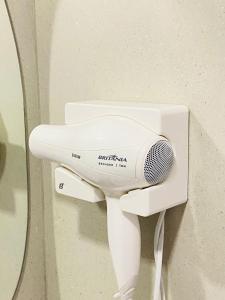 a white hair dryer on a wall next to a mirror at Ocean Porto Flats in Porto De Galinhas +57 photos