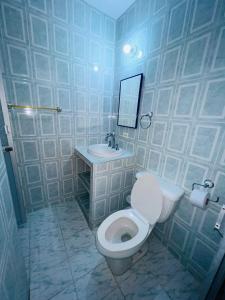y baño con aseo blanco y lavamanos. en HOTEL COLONIAL, en Barrancabermeja