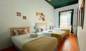 1 dormitorio con 2 camas y ordenador portátil en la parte superior en Algarve HOSTEL, en Faro