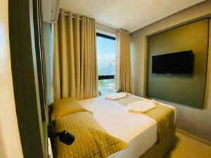 pokój hotelowy z łóżkiem i dużym oknem w obiekcie Ocean Porto Flats w mieście Porto de Galinhas