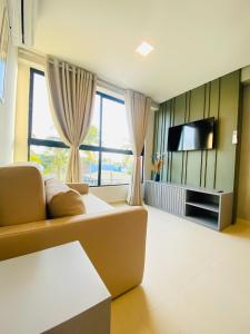 a living room with a couch and a flat screen tv at Ocean Porto Flats in Porto De Galinhas