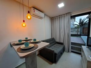 Apartamento com piscina no Condominio Maraca2 في إيبوجوكا: غرفة معيشة مع طاولة وأريكة