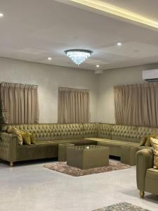 a living room with a large couch and a table at منتجع لامة مدر in Al Wudayy