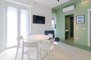 a dining room with a white table and chairs at SAN SIRO BLUE FLAT in Milan