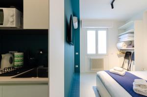 a room with a bed and a kitchen with a sink at SAN SIRO BLUE FLAT in Milan +25 photos