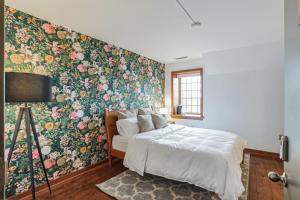 ein Schlafzimmer mit einer Wand mit floralen Akzenten und einem Bett in der Unterkunft Overlook Brandywine Valley 