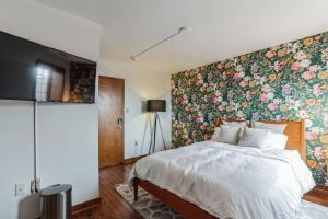 ein Schlafzimmer mit einer Wand mit floralen Akzenten und einem Bett in der Unterkunft Overlook Brandywine Valley 