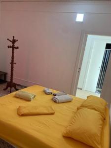 a yellow bed with two pillows and a cross on it at Gargano Home in Vieste