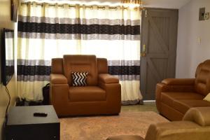 sala de estar con sofá y silla en Dennis prince comfy home, en Nairobi