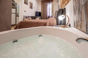 a bath tub filled with water in a room at Casa Vacanze RetroScena in Avola +23 photos