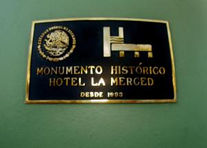 Una señal para un hotel la merced en una pared en Hotel La Merced en Colima
