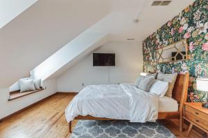 Un dormitorio con una cama con una pared de acento floral en Historic Thornton Studio Retreat, 