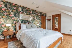 1 dormitorio con 1 cama grande y papel pintado con motivos florales en Historic Thornton Studio Retreat, 