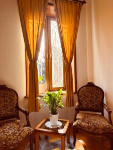 Habitación con 2 sillas, mesa y ventana en Hotel Tamar Mepe, en Kutaisi