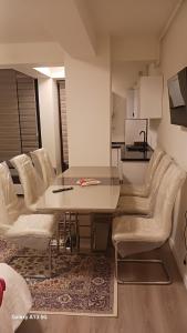 une salle à manger avec une table et des chaises blanches dans l'établissement Trio Maria, à Otopeni