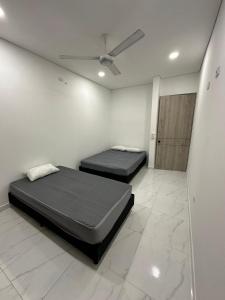 two beds in a white room with a ceiling at Casa privada con piscina Villa Encanto in Carmen de Apicalá