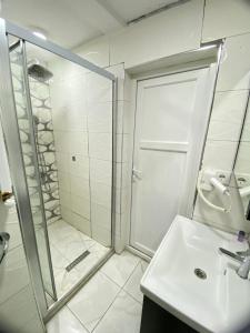 een witte badkamer met een douche en een wastafel bij Unique Suite - On the Kadıköy seaside in Istanbul