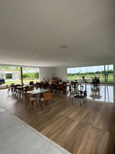 uma sala de jantar com mesas, cadeiras e janelas em Villa'S Roraima - Pousada & Natureza em Boa Vista