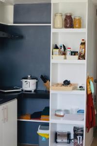 a pantry with white shelves with food and other items at Modern Oasis*Heart of City*Fast Wi-Fi/Netflix WFH in Iloilo City