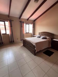 a bedroom with a bed and a tiled floor at Hermosa y cómoda casa en Cochabamba in Cochabamba