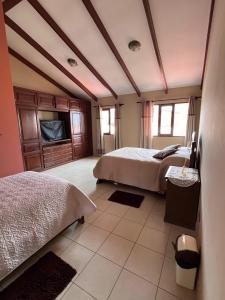 a bedroom with two beds and a tv at Hermosa y cómoda casa en Cochabamba in Cochabamba +43 photos