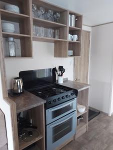 a kitchen with a stove and cabinets with dishes at Swanns retreat in Tattershall