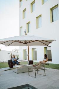 2 personnes assises dans des chaises sous un parapluie dans l'établissement Gran Hotel Concordia, à Irapuato