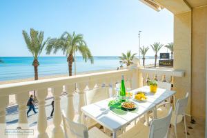 een tafel op een balkon met uitzicht op het strand bij Apartment front line Jakarta 1 Sea View in El Campello