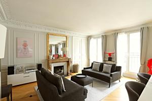 ein Wohnzimmer mit einem Sofa und einem Spiegel in der Unterkunft Luxurious Flat Place Vendome in Paris