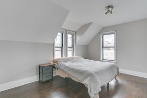a white bedroom with a bed and two windows at Pet-Friendly Malden Apartment 7 Mi to Boston! in Malden