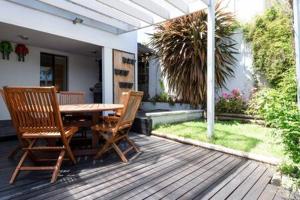 una terrazza in legno con tavolo e 2 sedie di Funky Heritage Home in the City Center a Launceston