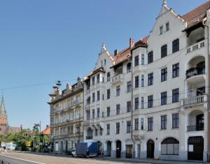 a large white building on the side of a street at Kopernik Premium Rooms Apartment in Toruń