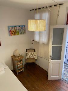 um quarto com uma cama, uma cadeira e um lustre em La casona de Palermo Hostel Boutique em Buenos Aires