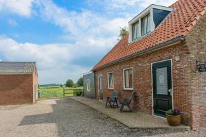 a brick building with two chairs outside of it at Buitenplaats Langewijk in Zuidoostbeemster