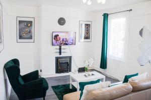 een woonkamer met een bank en een open haard bij Stunning 1-Bedroom House in Crystal Palace London in Londen
