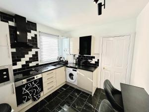 - une cuisine avec du carrelage noir et blanc sur le mur dans l'établissement Stunning 1-Bedroom House in Crystal Palace London, à Londres