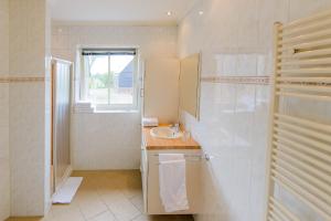 a white bathroom with a sink and a mirror at Buitenplaats Langewijk in Zuidoostbeemster +17 photos