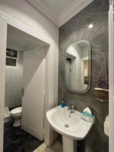 een badkamer met een wastafel, een toilet en een spiegel bij شقة فاخرة بدخول ذاتي/غرفة و صالة و مطبخ و حمام in Riyad