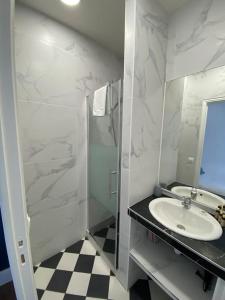 ein weißes Bad mit einem Waschbecken und einer Dusche in der Unterkunft studio BORDEAUX CHARTRONS 2 in Bordeaux