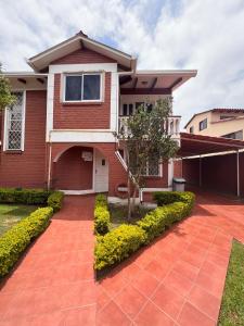 a house with a red brick driveway at Hermosa y cómoda casa en Cochabamba in Cochabamba