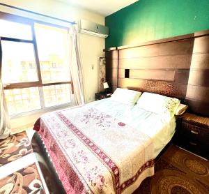 1 dormitorio con cama grande y ventana grande en Grand Madinaty 2 with Garden view, en Madinaty