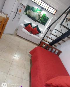 a living room with a red bed and a couch at Bruna Departamentos in San Fernando del Valle de Catamarca