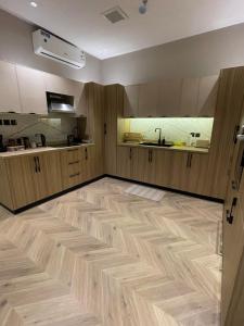 a kitchen with wooden cabinets and a wooden floor at شقة فاخرة بمدخل طراز سلماني in Riyadh