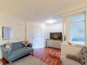 uma sala de estar com um sofá azul e uma televisão em 5 Bed in Yorkshire Dales 81390 em Richmond