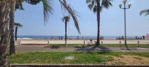 a park with palm trees and the beach in the background at 4 couchages Front de Mer Clim Parking privatif Wifi in Nice